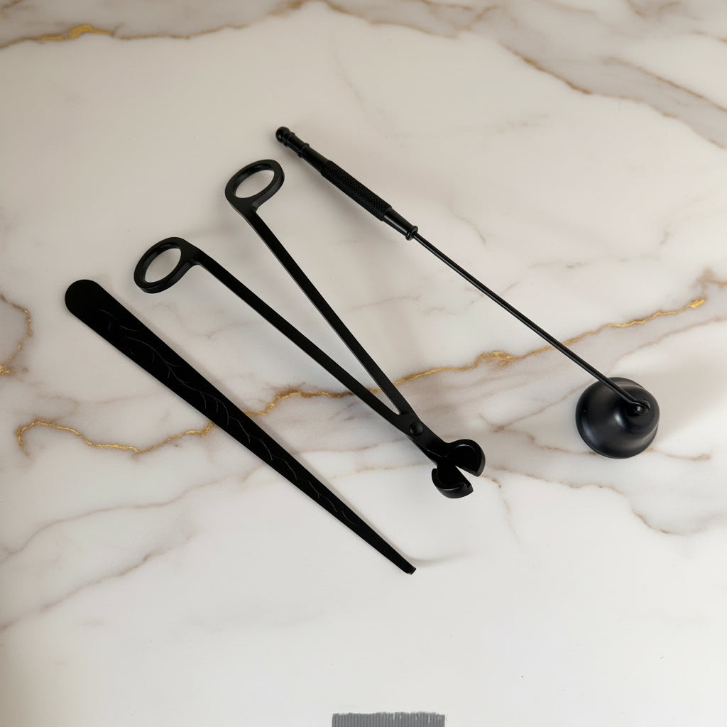 Set of black metal candle care tools on a white background